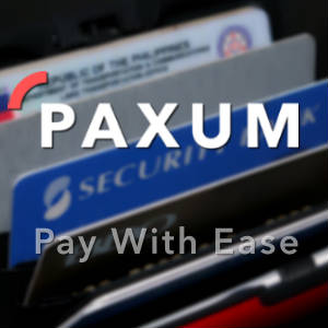 Out of focus photo of credit cards with the Paxum logo and motto superimposed.