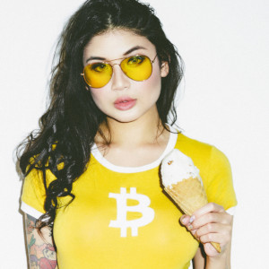 Brenna Sparks in a tight yellow top, with Blockchain logo, holding an ice cream cone.