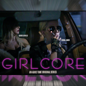 A still from Girlcore, with Cherrie DeVille in the back seat of a car driven by Kenna James, who's also wearing dark glasses and smoking a cigarette.
