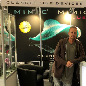 Photo of Jules Jordan standing at the Clandestine Devices booth in Hanover, Germany.