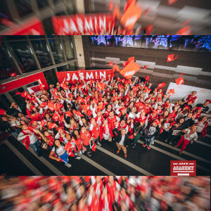 A high, wide photo of Jasmin Academy students raising arms to the camera - lotsa red!