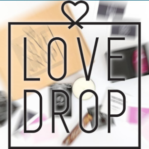 The LoveDrop logo is superimposed over a zoom-blurry background of the contents of a subscription box.