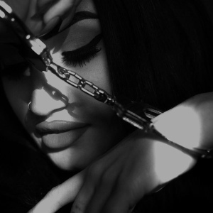A dramatic black and white close-up of Jane Jett, leaning her jaw on a handcuffed hand...