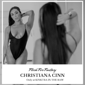 A class, elegant black & white photo of Christiana Cinn, from behind, reflected in a mirror, wearing a black one-piece bathing suit and framed in a white border captioned with her appearance on the Kinktra podcast.