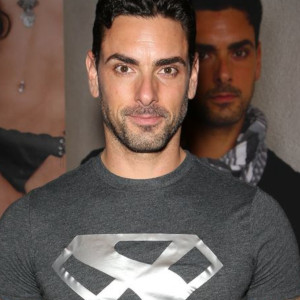 A behind-the-scenes photo of Ryan Driller relaxed in a t-shirt and five o'clock shadow at an AVN event.